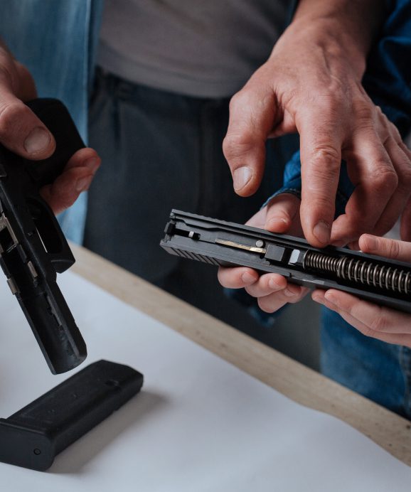 Hands assembling or disassembling a handgun.