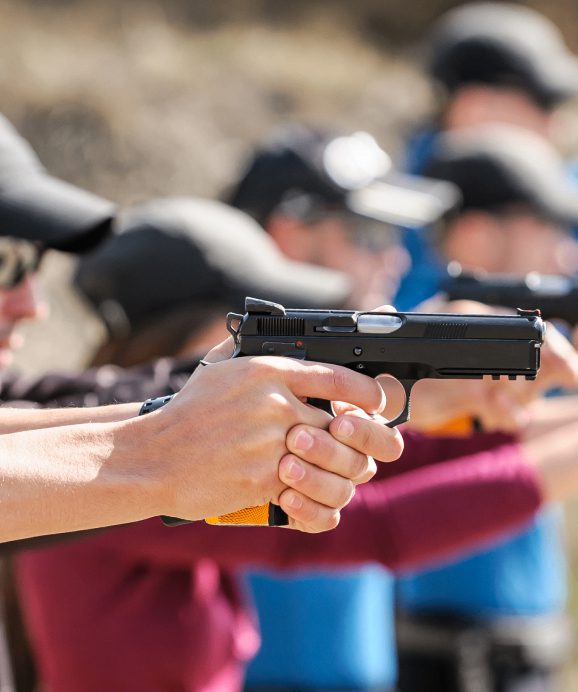 People aiming pistols at a shooting range.