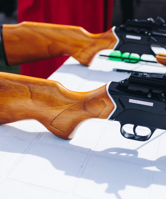 Wooden rifles displayed on a white table.