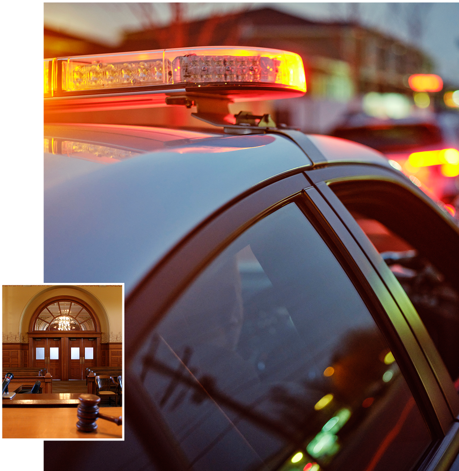 Police cars with flashing lights at dusk in an urban setting.