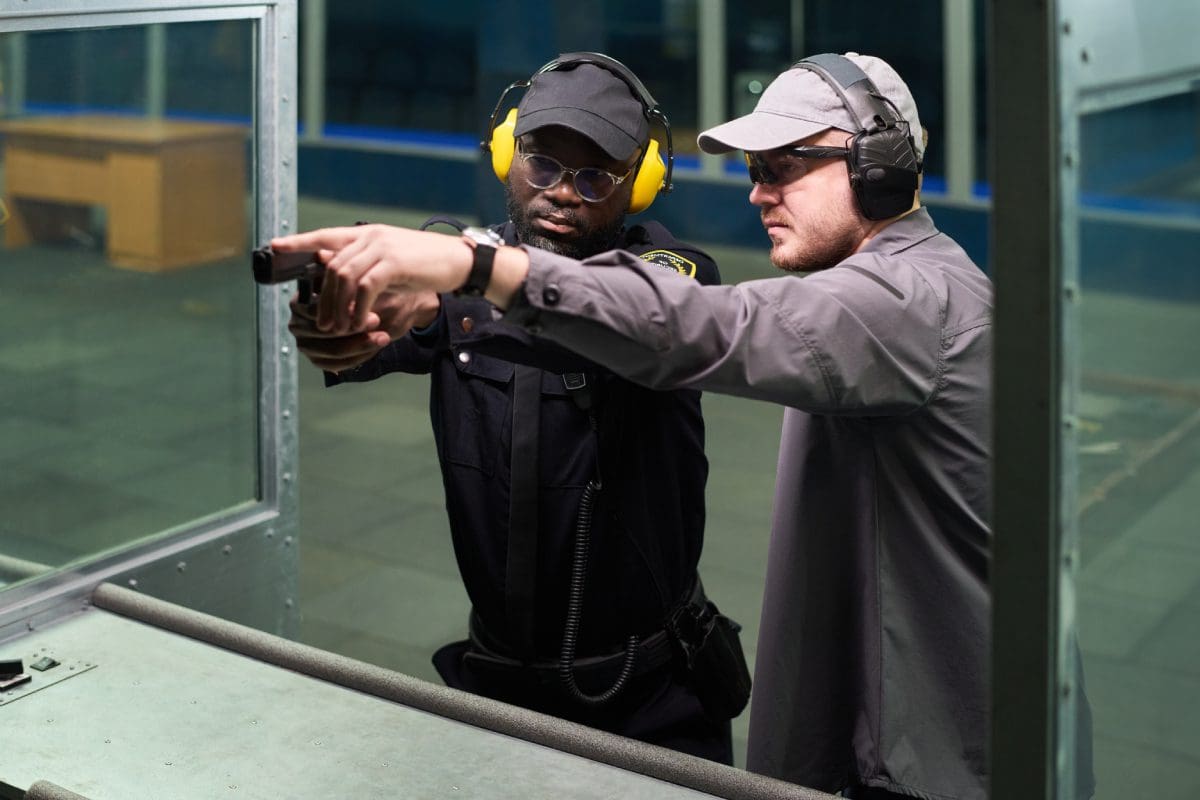 Man instructing another in shooting range.