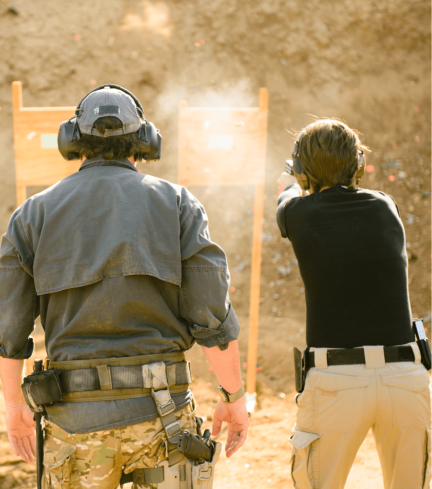 Two people practicing shooting at targets.