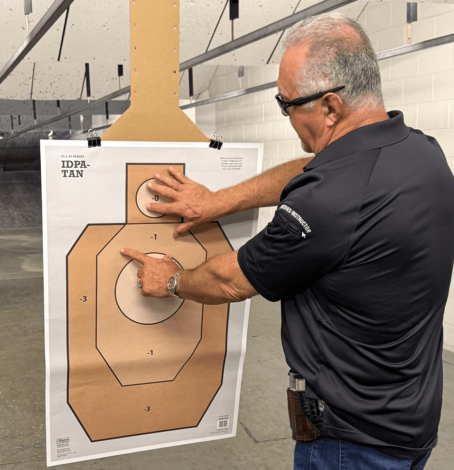 Man examining shooting target at range.