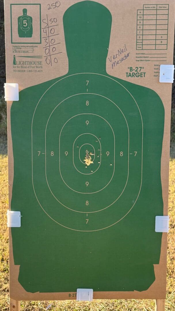 A green shooting target with multiple bullet holes clustered near the center.