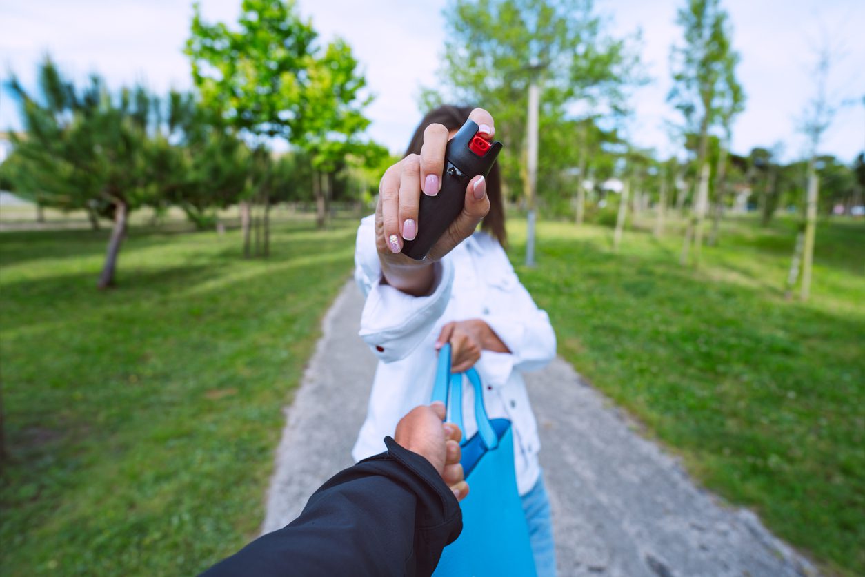 Person handing over keys while carrying shopping bags outdoors.