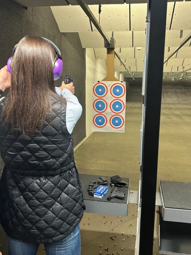 Person shooting at a target indoors.