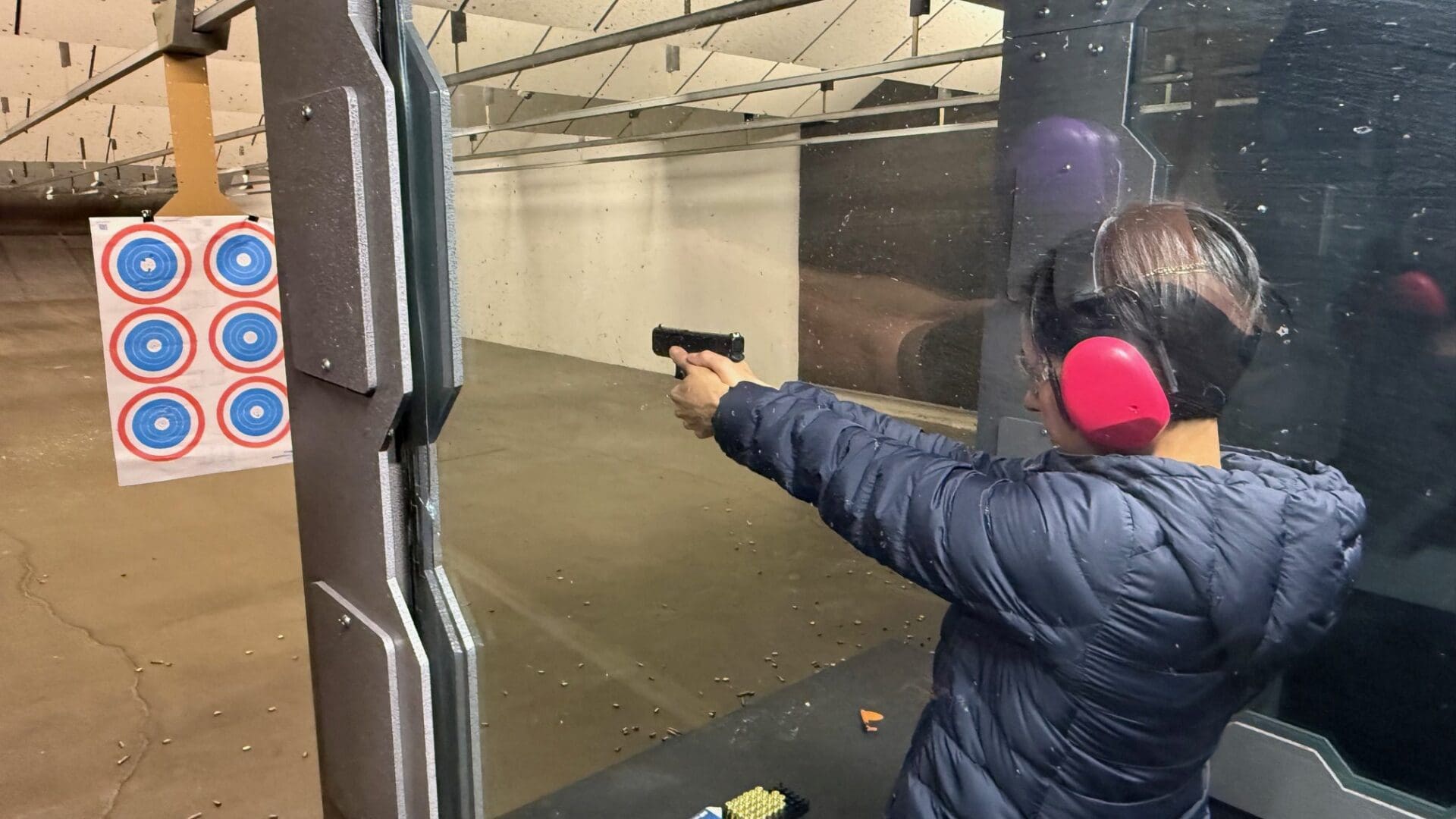 Person shooting at targets in indoor range.
