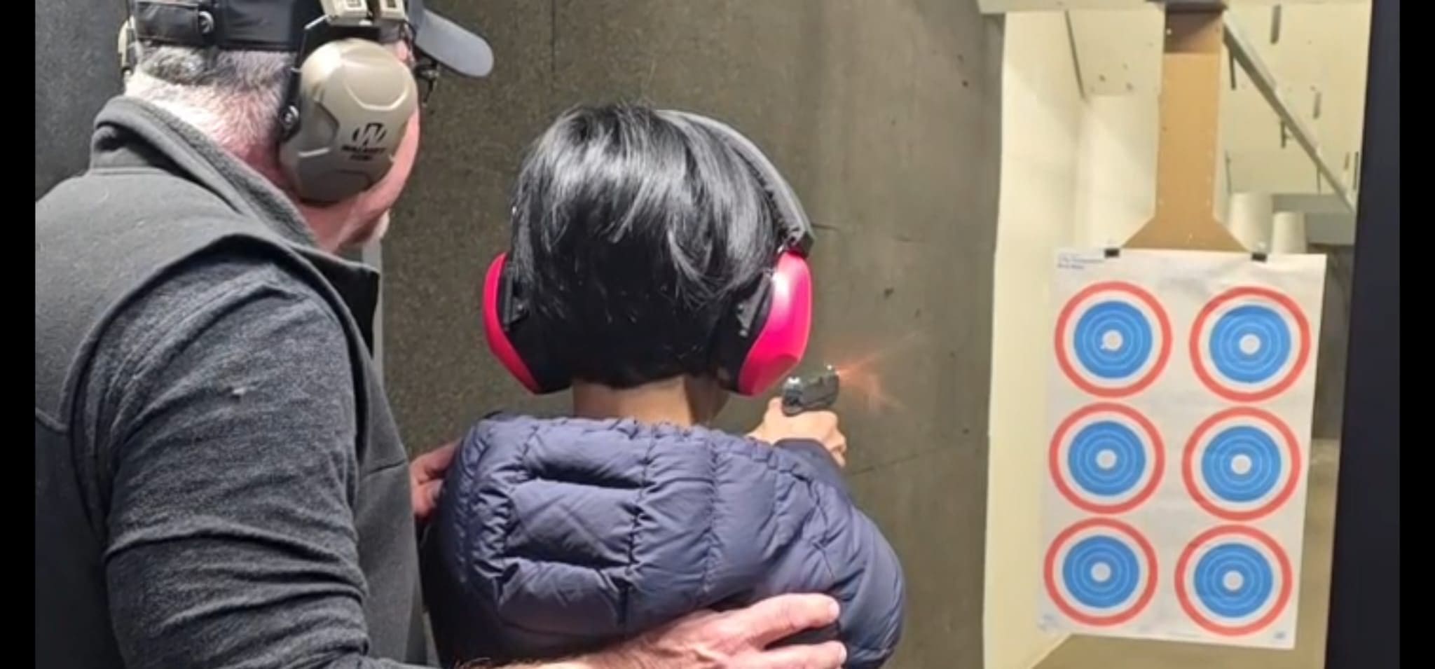 Man and woman at shooting range, aiming.