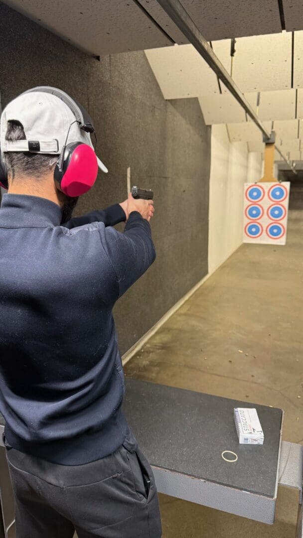 Person aiming pistol at shooting range target.
