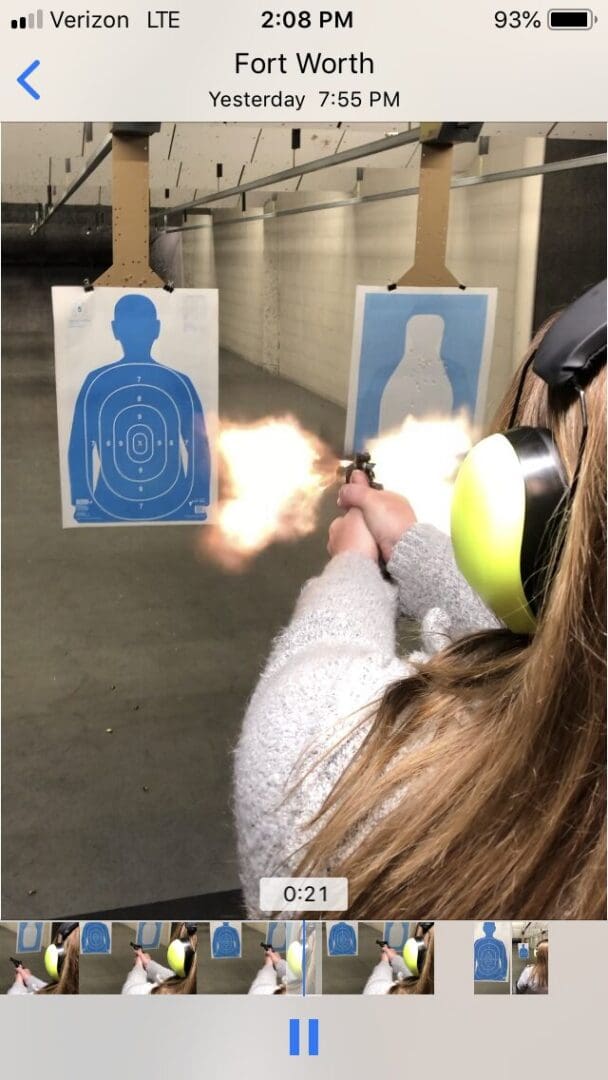Person firing handgun at indoor shooting range